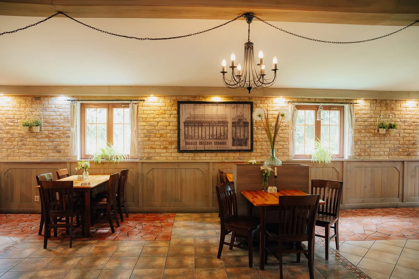 Sala restauracyjna Złotego Lina z drewnianymi stołami, krzesłami i żyrandolem