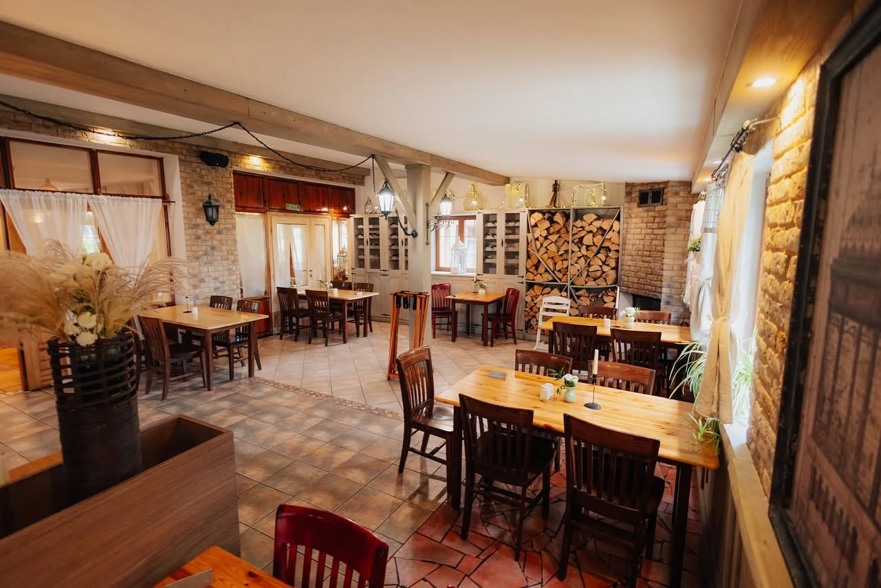 Sala restauracji Złoty Lin z drewnianymi stołami i kominkiem