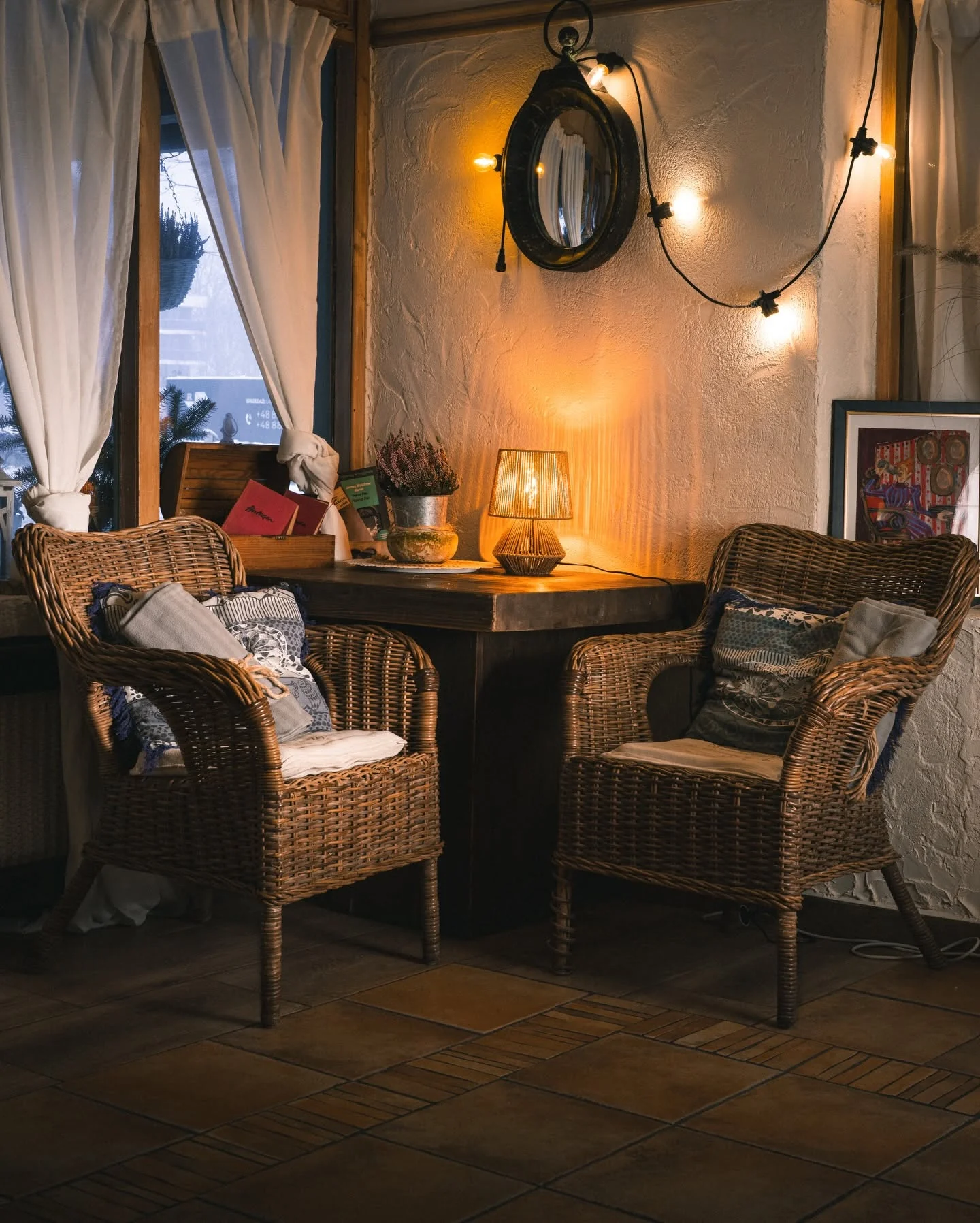 Kącik z wiklinowymi fotelami i lampą we wnętrzu Złotego Lina